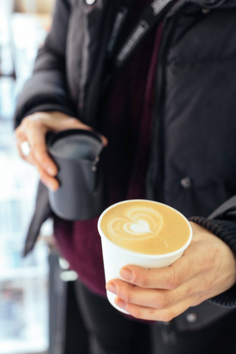 Café con leche recién preparado en cafetería NEWS&COFFEE con dibujo de corazón